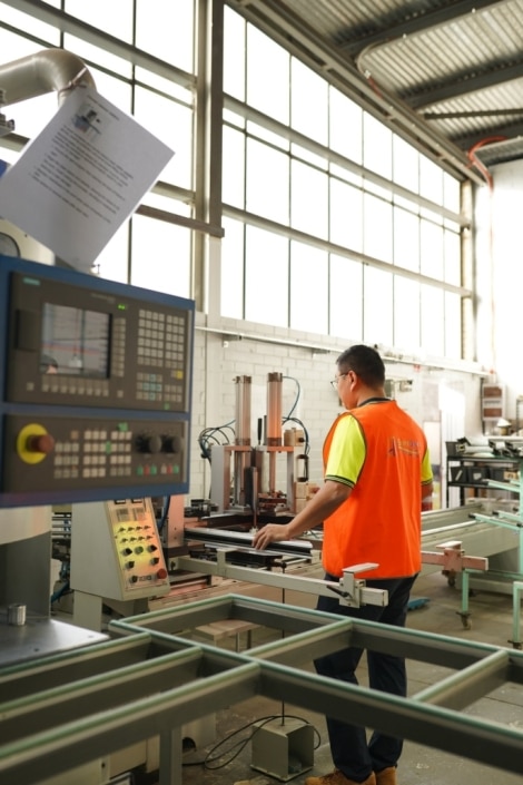 Technician operating machinery for UPVC window production